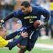 Jason Eldridge reaches after ball carrier Alijah Bradley during the Victors Classic alumni football game at Michigan Stadium on Saturday. Melanie Maxwell I AnnArbor.com